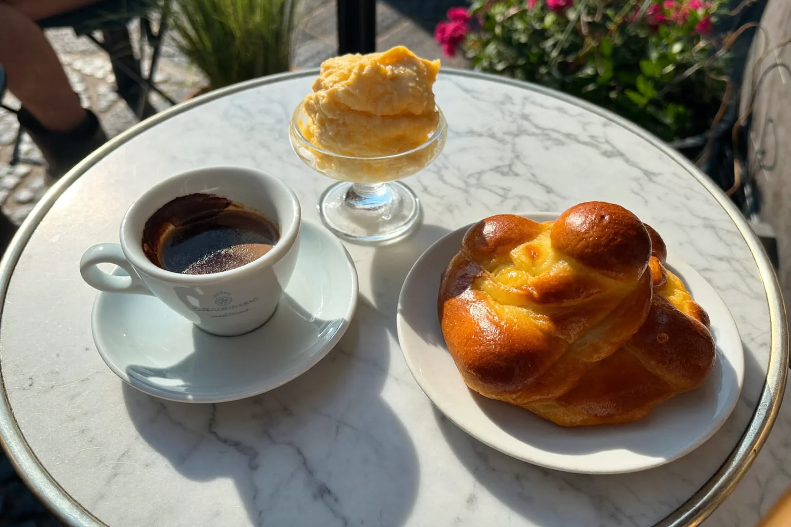 Caffè, brioche e granita su un tavolino di marmo